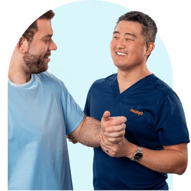 Smiling healthcare professional assisting a patient with arm exercises