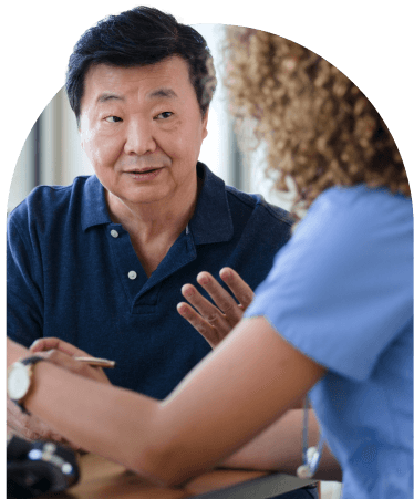 Male patient in a discussion with a healthcare professional in blue scrubs