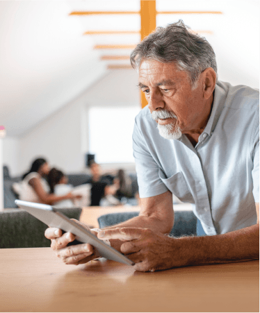 Senior man researching Medicare options from Optum Oregon on a tablet